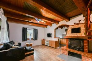 a living room with a fireplace and wooden ceilings at Guest House Martin in Korana