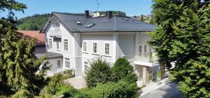 une grande maison blanche avec un toit noir dans l'établissement Villa Wickenburg, à Salzbourg
