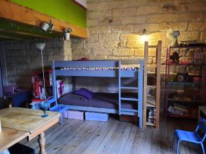 een kamer met 2 stapelbedden en een tafel bij Chambres de charme chez l'habitant in Baillargues