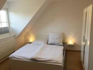 a bedroom with a bed with two pillows and a window at Ferienwohnung Alte Räucherei DH-60114 in Lubmin