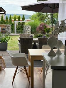 eine Terrasse mit einem Tisch, Stühlen und einem Sonnenschirm in der Unterkunft Vila Martina in Popůvky