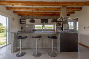 una cocina con una encimera grande con taburetes. en Casa en chacras de coria en Mendoza