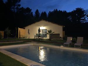 uma piscina em frente a uma casa à noite em Villa La source & SPA em Pont-de-Labeaume