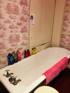 a bath tub with a pink towel on it at Westbrook-Homestay in Swansea