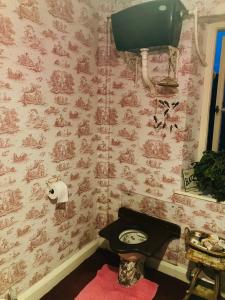a bathroom with a clock on a pink wall at Westbrook-Homestay in Swansea