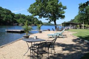 a picnic table and chairs next to a lake at #03 - Fantastic Lakeside Studio Cottage- Pet Friendly in Hot Springs