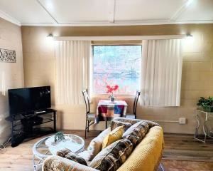 un salon avec un canapé et une table dans l'établissement #03 - Fantastic Lakeside Studio Cottage- Pet Friendly, à Hot Springs