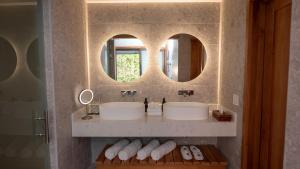 a bathroom with two sinks and two mirrors at Tabacón Thermal Resort & Spa in Fortuna