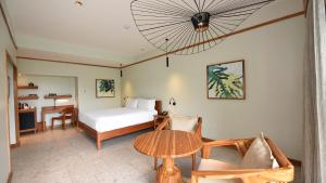 a bedroom with a bed and a table in a room at Tabacón Thermal Resort & Spa in Fortuna