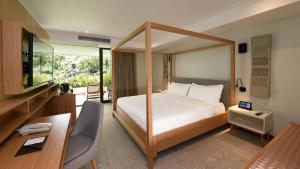 a hotel room with a bed and a desk and a desk at Tabacón Thermal Resort & Spa in Fortuna