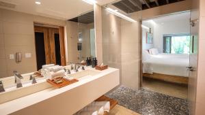 a bathroom with a large mirror and a bed at Tabacón Thermal Resort & Spa in Fortuna