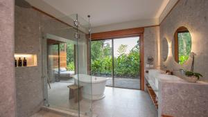 a bathroom with two sinks and a tub and a shower at Tabacón Thermal Resort & Spa in Fortuna