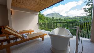 a bathroom with a toilet and a balcony with a view at Tabacón Thermal Resort & Spa in Fortuna
