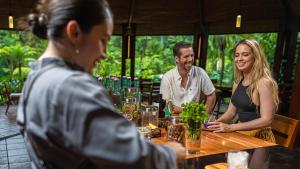 un grupo de personas sentadas alrededor de una mesa en un restaurante en Tabacón Thermal Resort & Spa en Fortuna