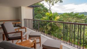 a balcony with chairs and a view of the mountains at Tabacón Thermal Resort & Spa in Fortuna