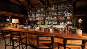 a bar with chairs and a counter with alcohol bottles at Tabacón Thermal Resort & Spa in Fortuna