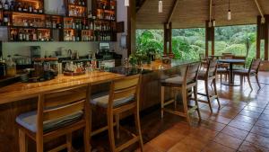 a bar in a restaurant with wooden tables and chairs at Tabacón Thermal Resort & Spa in Fortuna
