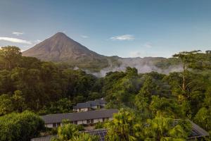 a mountain in the middle of a forest with a building at Tabacón Thermal Resort & Spa in Fortuna