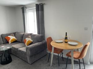 a living room with a couch and a table at Buckshaw Snoozy in Heapey