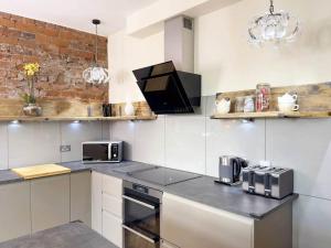 a kitchen with white appliances and a brick wall at The Yorkshire Hosts - Knights Stay 