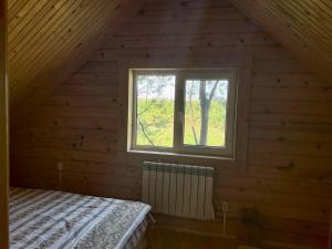 an attic room with a bed and a window at Family Resort in Mostiska
