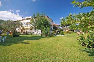 a green yard with a house and a building at Anna -House Maria Manolaki, 2-Βedrm Apartment in Vourvourou