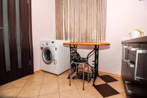 a kitchen with a table and a washing machine at Seklytėlė 1 in Palanga