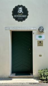 eine grüne Garagentür mit einem Schild darüber in der Unterkunft CA' HEMINGWAY in Bassano del Grappa