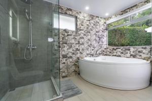 a bathroom with a tub and a glass shower at House of Turri Suite, Views & Jacuzzi in Verbena Norte
