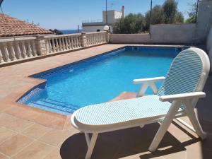 a chair sitting next to a swimming pool at CAN TRULLEN CHALET CALAFELL in Calafell