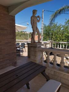 a statue of a boy on a patio with a bench at CAN TRULLEN CHALET CALAFELL in Calafell