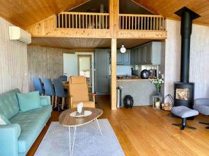 ein Wohnzimmer mit einem Sofa und einem Tisch in der Unterkunft Cozy cabin w/garden, BBQ, canoe, swimming, central in Sinnes