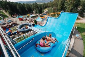 a group of people riding down a water slide at a water park at Cozy cabin w/garden, BBQ, canoe, swimming, central in Sinnes