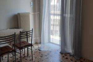ein Zimmer mit zwei Stühlen, einem Tisch und einem Fenster in der Unterkunft Βαγγέλης in Kardítsa