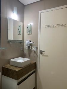 a bathroom with a white sink next to a door at Cantinho do Ceu in Cachoeira Paulista