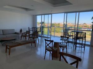 a dining room with tables and chairs and windows at Cantinho do Ceu in Cachoeira Paulista