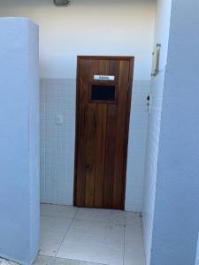 a wooden door in a bathroom with white tiles at Cantinho do Ceu in Cachoeira Paulista