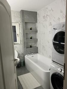 a white bathroom with a tub and a toilet at Neagoe residents in Birkirkara