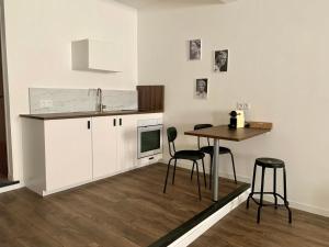 a kitchen with white cabinets and a table and chairs at Studio Via Romana Vaison La Romaine in Vaison-la-Romaine +17 photos