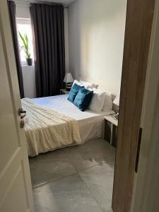 a bedroom with a bed with a blue pillow on it at Neagoe residents in Birkirkara