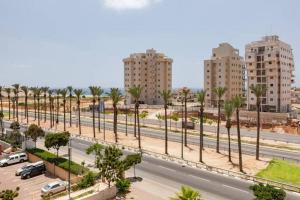 una calle de la ciudad con palmeras y edificios en Netanya Family Apartment with Balcony by FeelHome, en Netanya