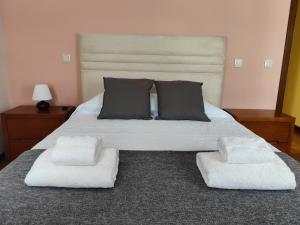 una camera da letto con un grande letto con due sedie bianche di Casinha da Vila a Arouca