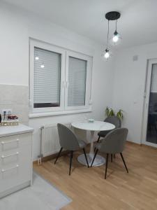 cocina y comedor con mesa y sillas en Apartman Centar Kozarska Dubica, en Bosanska Dubica