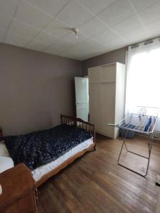 una camera con un letto in una stanza con pavimenti in legno di F2 meublé centre de gien a Gien