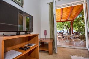 a living room with a flat screen tv and a balcony at Ferienhaus Elena, Karlobag in Karlobag