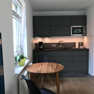 uma pequena cozinha com uma mesa de madeira e um lavatório em Kleine Auszeit em Rosdorf