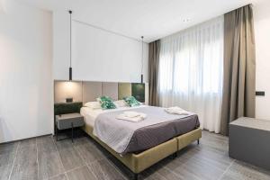 a bedroom with a large bed with green pillows at ML luxury room in Lido di Spina