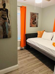mały pokój z łóżkiem i pomarańczową zasłoną w obiekcie 3bdrm Fruit Tree Home near downtown Orlando w Orlando