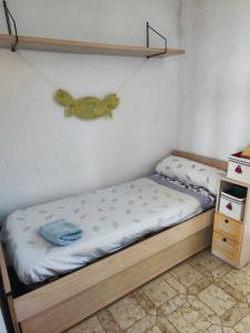Cama pequeña en habitación con estantería en Pequeña casa rural en el centro del Delta del Ebro, en Amposta