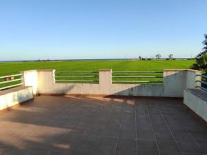 un patio con valla y césped en Pequeña casa rural en el centro del Delta del Ebro, en Amposta